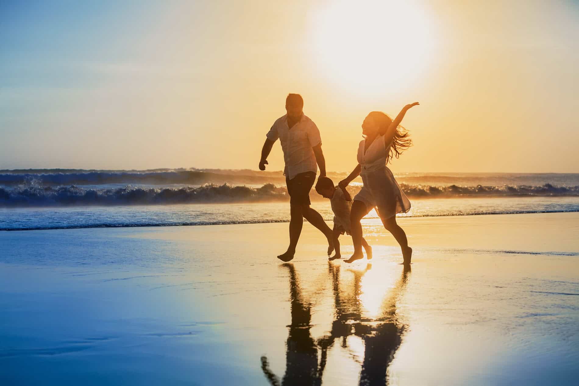 Family walking on Maui beach during sunset happily.
