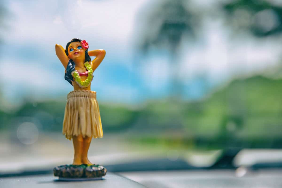 Hula girl figurine on a car dashboard from Maui as a souvenir.
