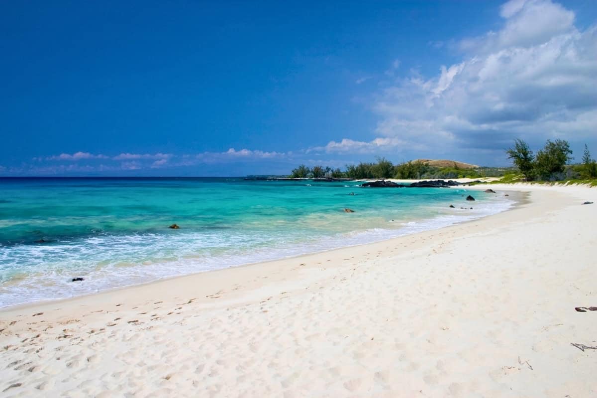Makalawena Beach Stunning Makalawena Beach with its white sandy shore, inviting clear waters, and a brilliant blue sky overhead.