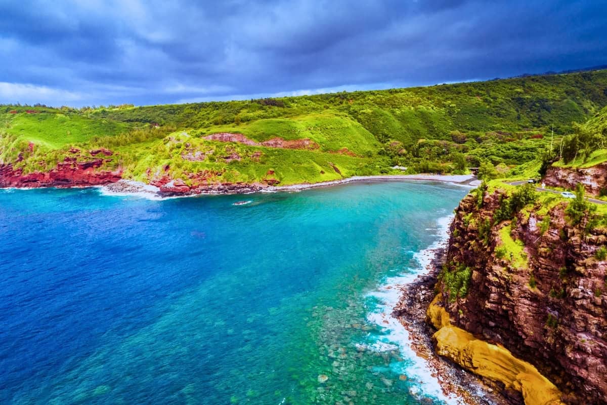Scenic view of the Road to Hana in Maui, showcasing lush greenery and coastal cliffs under a clear blue sky.
