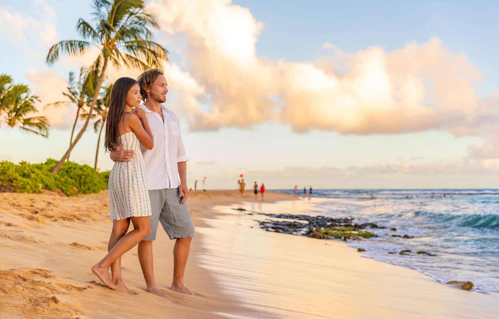 Couple,On,Romantic,Sunset,Beach,Walk,Relaxing,During,Hawaii,Summer A couple standing on the beach at golden hour on Maui.