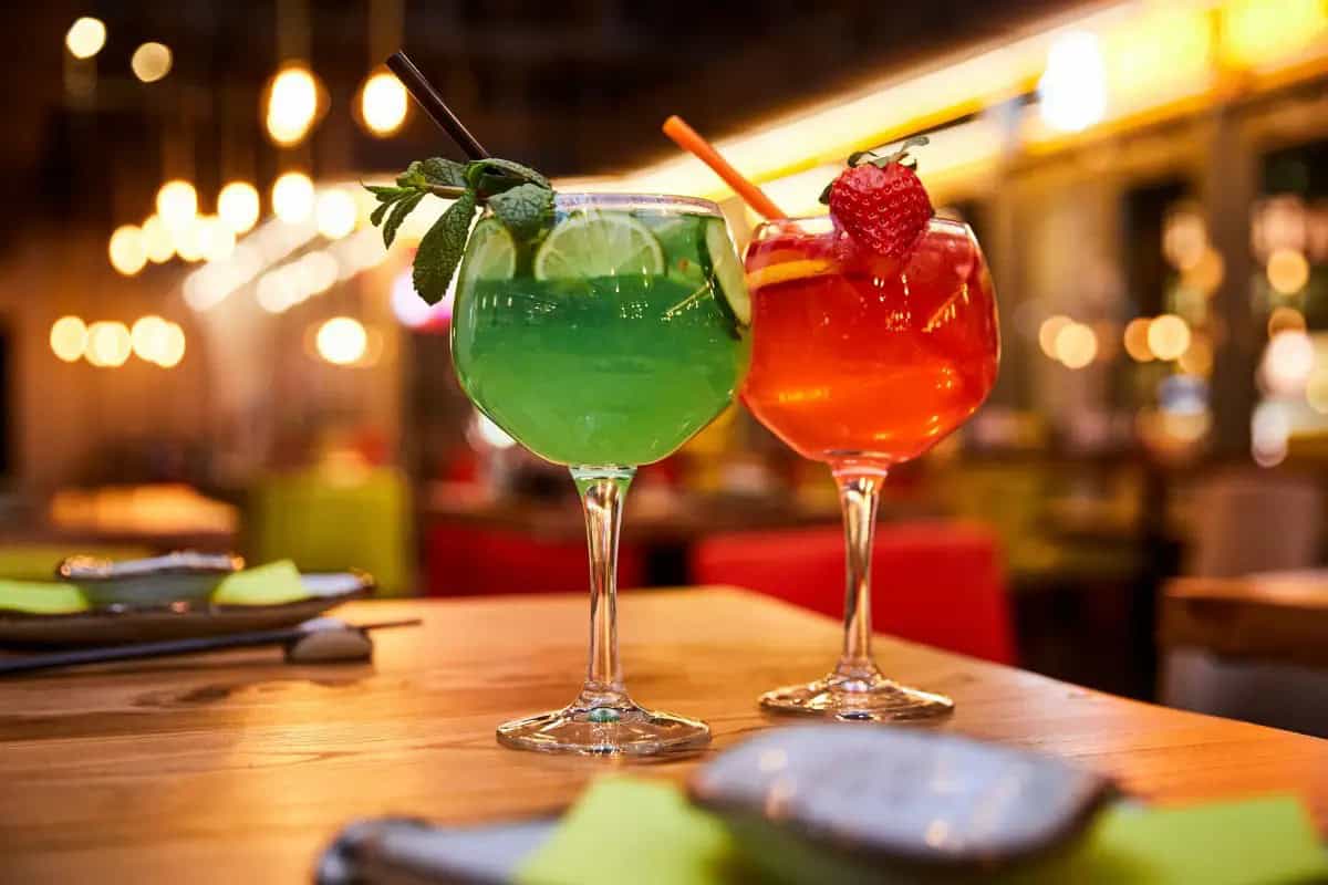 Two vibrant cocktails on a wooden table during Maui nightlife.
