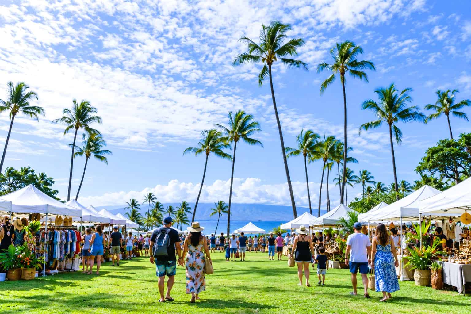 Maui Events Outdoor Festival Outdoor Maui festival with white vendor tents, palm trees, and visitors.